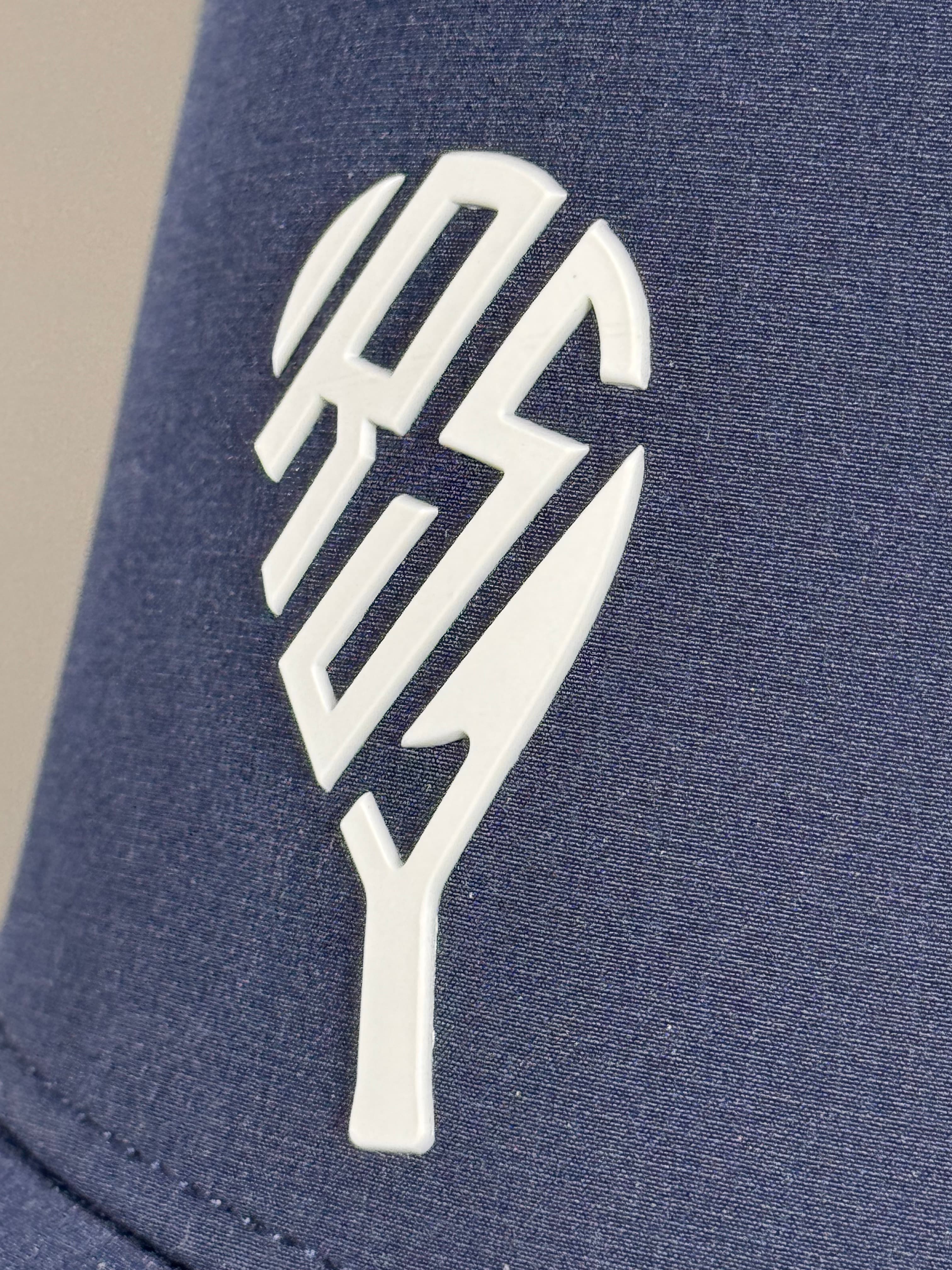 Close-up of the raised white Rally front logo on navy court hat fabric